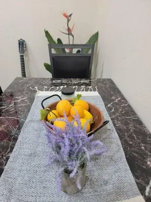 a vase of oranges and flowers on a table at Exotic Gem Relaxing Farm Vibes Near Safari Zoo, Legoland & Wineries in Escondido