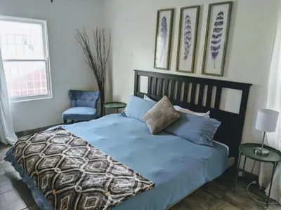 a bedroom with a bed with blue sheets and a chair at Centrally Located 2 Master Bedrooms to Explore all San Diego has to Offer in San Diego