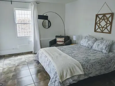 a bedroom with a bed and a chair and a window at Centrally Located 2 Master Bedrooms to Explore all San Diego has to Offer in San Diego