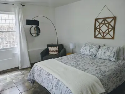 a bedroom with a bed and a chair and a window at Centrally Located 2 Master Bedrooms to Explore all San Diego has to Offer in San Diego