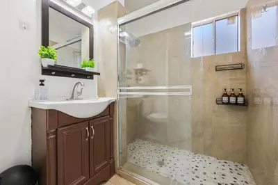 a bathroom with a shower with a sink and a glass shower stall at Spacious Family Retreat in the heart of San Diego in San Diego