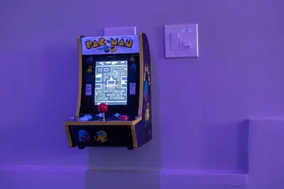 a video game machine is on a purple wall at NEW! Pt Loma Paradise: Remodel - Pool – Game Room – WOW! in San Diego