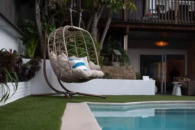 a hanging chair next to a swimming pool at NEW! Pt Loma Paradise: Remodel - Pool – Game Room – WOW! in San Diego