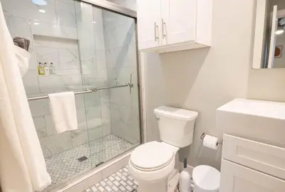 a white bathroom with a shower and a toilet at NEW! Pt Loma Paradise: Remodel - Pool – Game Room – WOW! in San Diego