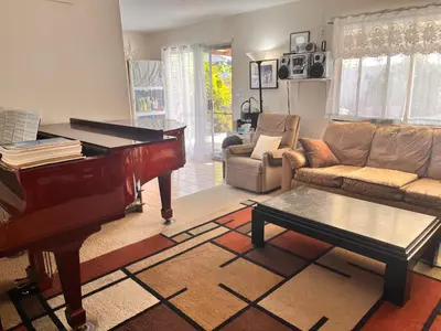 a living room with a piano and a couch at A Bridge to All San Diego Central Pool Home Private Room in San Diego