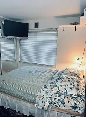 a bedroom with a bed with a tv on the wall at A Bridge to All San Diego Central Pool Home Private Room in San Diego