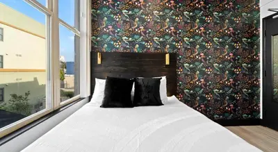 a bedroom with a large bed with a large window at Balboa Park Hotel Downtown Little Italy in San Diego