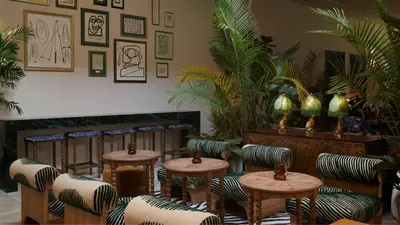 a waiting room with tables and chairs and plants at Granger Hotel San Diego Downtown Gaslamp Quarter, a Member of Design Hotels in San Diego