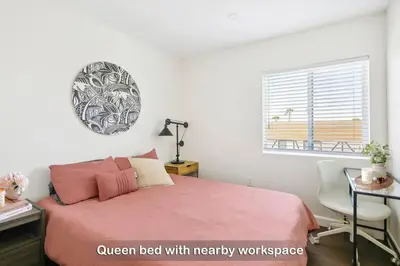 a bedroom with a pink bed with a desk and a window at Entire Private Home with 3 Bedrooms 3 Bathrooms, Balcony Views, 10-mins to San Diego Gaslamp, Downtown, Available Now in National City