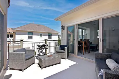 a patio with a couch and chairs on a balcony at Fun In The Sun 2 Bed 2 Bath Home in Oceanside