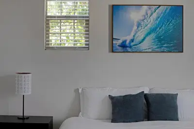a bedroom with a white bed and a window with a wave at Fun In The Sun 2 Bed 2 Bath Home in Oceanside
