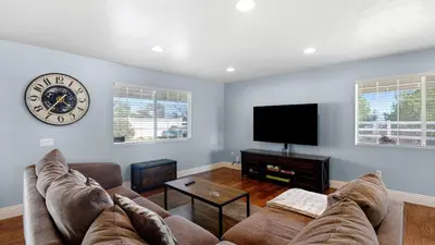 a living room with a couch and a clock on the wall at Wine Country Retreat Gorgeous Views Minutes to Wineries in Temecula