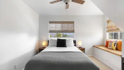a bedroom with a bed and two windows at Wine Country Retreat Gorgeous Views Minutes to Wineries in Temecula