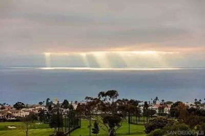 a rainbow in the sky over a field with houses at La Jolla Ocean View Mansion 2 in San Diego