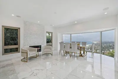 a white living room with a table and chairs at La Jolla Top Of The World Mansion in San Diego