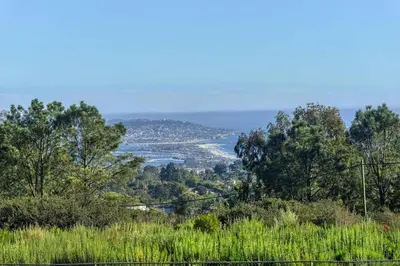 a view of a river from a hill with trees at La Jolla Top Of The World Mansion in San Diego