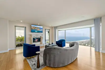 a living room with a couch and blue chairs at La Jolla Top Of The World Mansion in San Diego