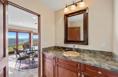a bathroom with a sink and a mirror and a table at Breathtaking Retreat in Escondido