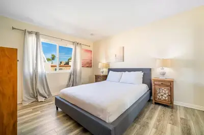 a bedroom with a large bed and a window at Charming Home Just Steps from the Beach 2 Bedroom, Private Back Patio, & Free WiFi in Newport Beach