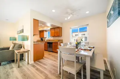 a kitchen and living room with a table and chairs at Charming Home Just Steps from the Beach 2 Bedroom, Private Back Patio, & Free WiFi in Newport Beach