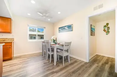 a kitchen and dining room with a table and chairs at Charming Home Just Steps from the Beach 2 Bedroom, Private Back Patio, & Free WiFi in Newport Beach