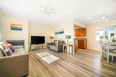 a living room with a couch and a television at Charming Home Just Steps from the Beach 2 Bedroom, Private Back Patio, & Free WiFi in Newport Beach