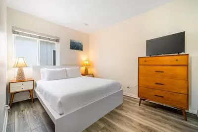 a bedroom with a bed and a dresser with a tv at Charming Home Just Steps from the Beach 2 Bedroom, Private Back Patio, & Free WiFi in Newport Beach
