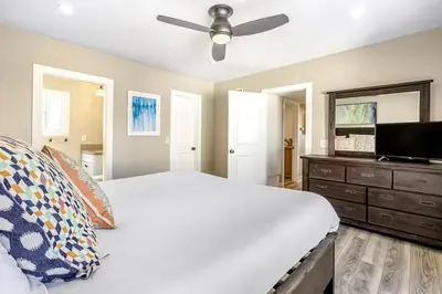 a bedroom with a white bed and a flat screen tv at Stunning 2nd Floor Beachfront Home with Balcony, Ocean Views, and Prime Location in Newport Beach