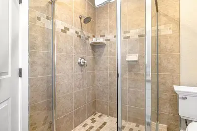 a shower stall with a glass door in a bathroom at Stunning 2nd Floor Beachfront Home with Balcony, Ocean Views, and Prime Location in Newport Beach