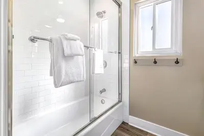 a bathroom with a shower with a glass door at Stunning 2nd Floor Beachfront Home with Balcony, Ocean Views, and Prime Location in Newport Beach