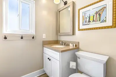 a bathroom with a toilet and a sink and a mirror at Stunning 2nd Floor Beachfront Home with Balcony, Ocean Views, and Prime Location in Newport Beach