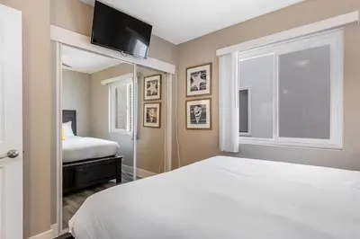 a bedroom with a white bed and a window at Oceanfront Oasis in Newport Beach Steps to Balboa Park, Pier, and The Fun Zone! in Newport Beach