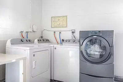 a white laundry room with a washer and dryer at Oceanfront Oasis in Newport Beach Steps to Balboa Park, Pier, and The Fun Zone! in Newport Beach