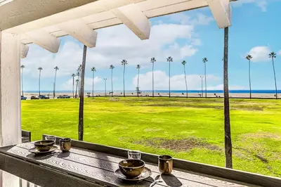 a table with a view of a field with palm trees at Oceanfront Oasis in Newport Beach Steps to Balboa Park, Pier, and The Fun Zone! in Newport Beach