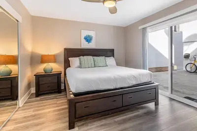 a bedroom with a bed and two lamps and a window at Beachside Oasis in Newport Beach Steps to Balboa Park, Pier, and The Fun Zone! in Newport Beach