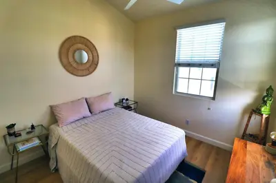 a bedroom with a bed and a mirror and a window at Sweet Pea Place, 2 bed with pool in Encinitas