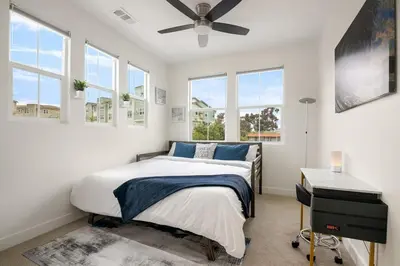 a bedroom with a bed and a ceiling fan at Makena By The Sea, 3 bed home near beach in Oceanside