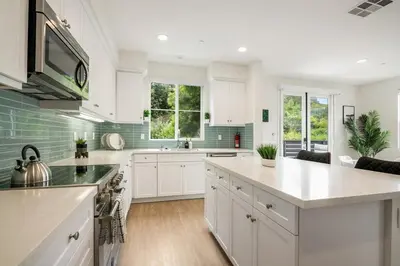 a kitchen with white cabinets and green tiles at Makena By The Sea, 3 bed home near beach in Oceanside