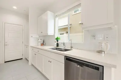 a white kitchen with a sink and a dishwasher at Sunnyside Up San Diego Gem in San Diego