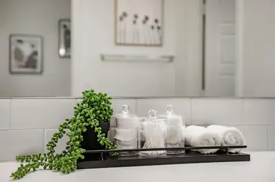 a shelf with towels and toiletries on a bathroom counter at Sunnyside Up San Diego Gem in San Diego