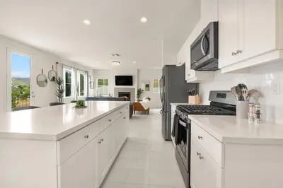 a kitchen with white cabinets and a stove top oven at Sunnyside Up San Diego Gem in San Diego