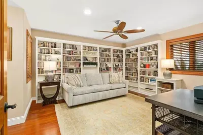 a living room with a couch and a ceiling fan at Enchanting French Inspired Chateau with Beach Club! in South Oceanside