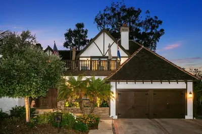 a house with a garage in front of it at Enchanting French Inspired Chateau with Beach Club! in South Oceanside