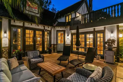 a house with a patio with chairs and a table at Enchanting French Inspired Chateau with Beach Club! in South Oceanside