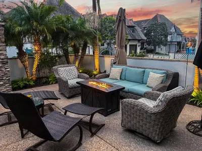 a patio with chairs and a couch and an umbrella at Enchanting French Inspired Chateau with Beach Club! in South Oceanside