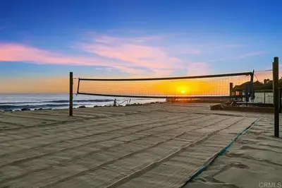 a volleyball net on the beach at sunset at Enchanting French Inspired Chateau with Beach Club! in South Oceanside