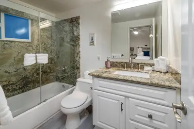 a bathroom with a toilet and a sink and a shower at Oceanfront 3BR Home with Pool Table & Patio in Newport Beach