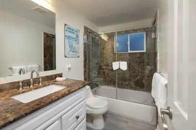 a bathroom with a sink and a toilet and a shower at Oceanfront 3BR Home with Pool Table & Patio in Newport Beach