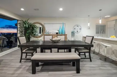 a dining room with a black table and chairs at 8BR Beach Duplex with Ocean Views, Patio & Pool Table in Newport Beach