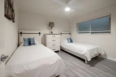 a bedroom with two beds and a window at 8BR Beach Duplex with Ocean Views, Patio & Pool Table in Newport Beach